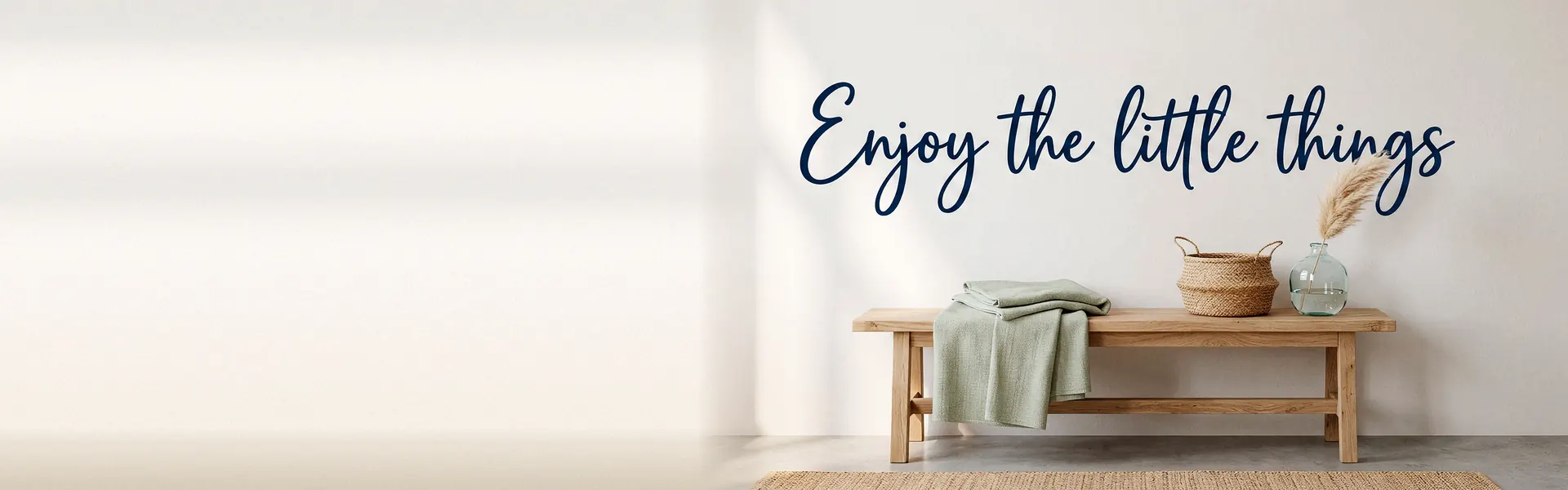 'Enjoy the little things' navy vinyl lettering above a wooden bench